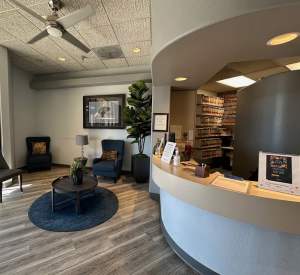 The image shows the interior of a modern, welcoming space, likely a dental office.